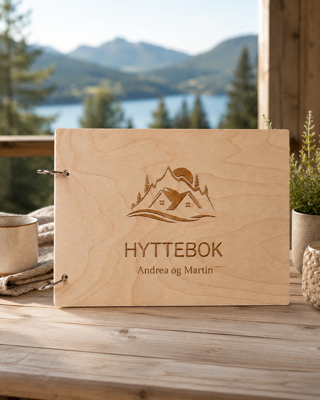 Personlig hyttebok i tre på hyttebord med kaffe, lys og naturdetaljer