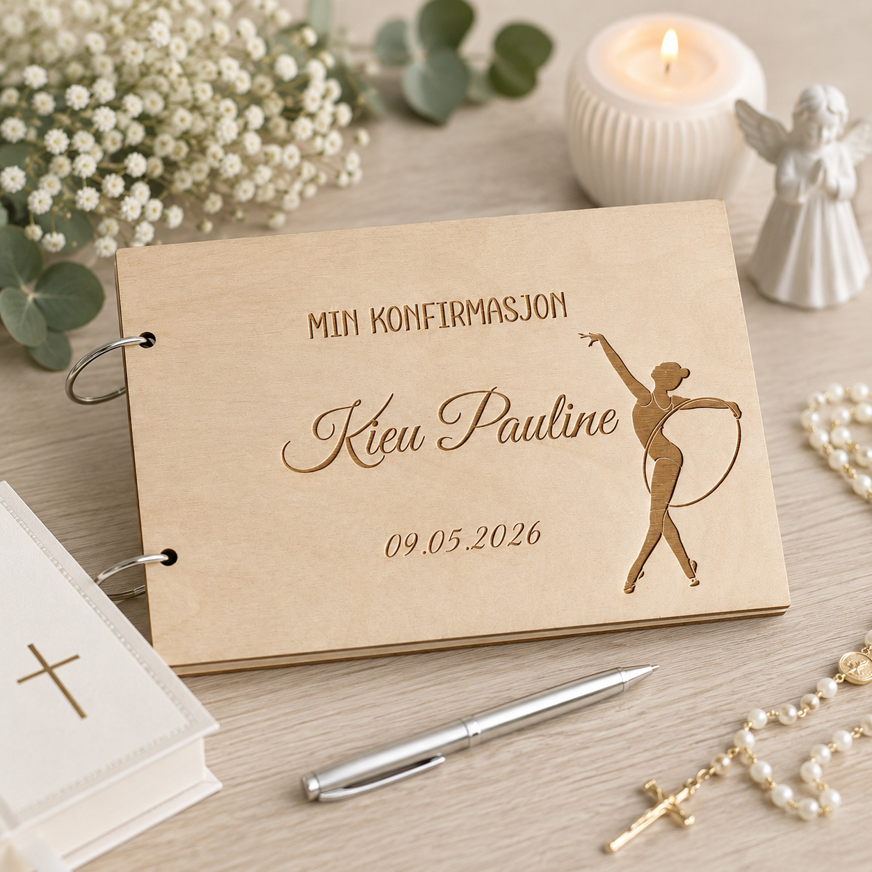 Personlig konfirmasjonsbok i tre med gravert navn og dato. Produktfoto med norsk bunad i uskarp bakgrunn og delikate konfirmasjonsdekorasjoner.
