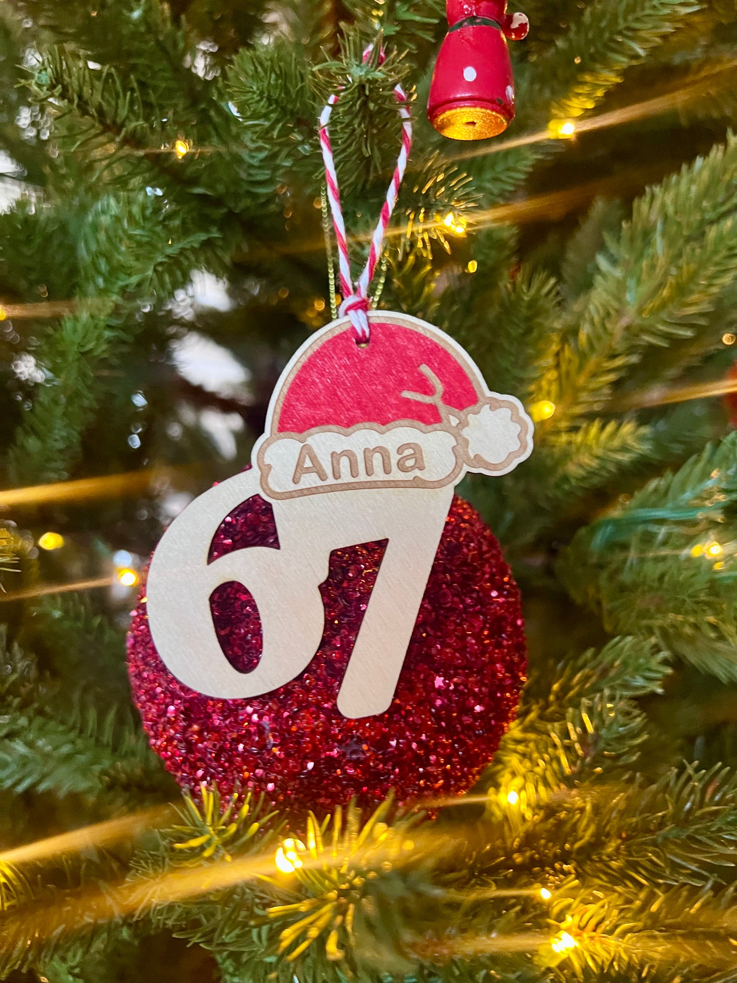 Ungdommelig julekule “67” – håndmalt rød kule med nisselue.