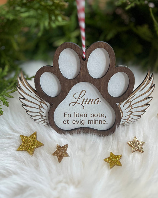 Håndlaget treornament for å minnes et kjæledyr, dekorert med englevinger.
