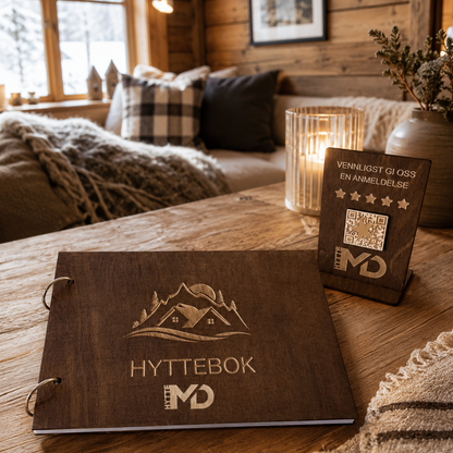 Brun hyttebok med gravert logo på lukket treomslag og to metallringer langs venstre side