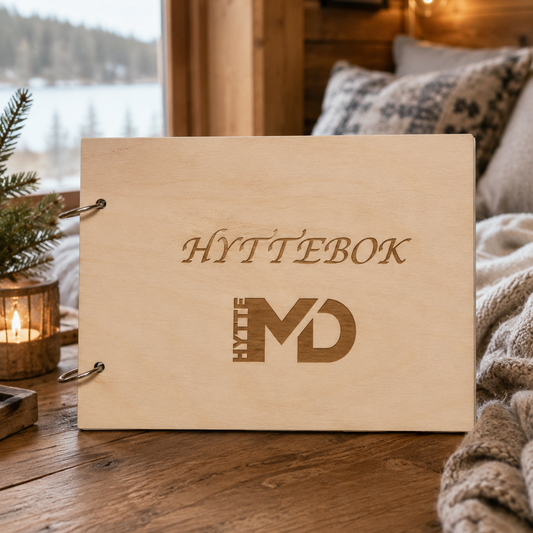 Hyttebok i tre med gravert kundelogo på omslaget og metallringer langs venstre side