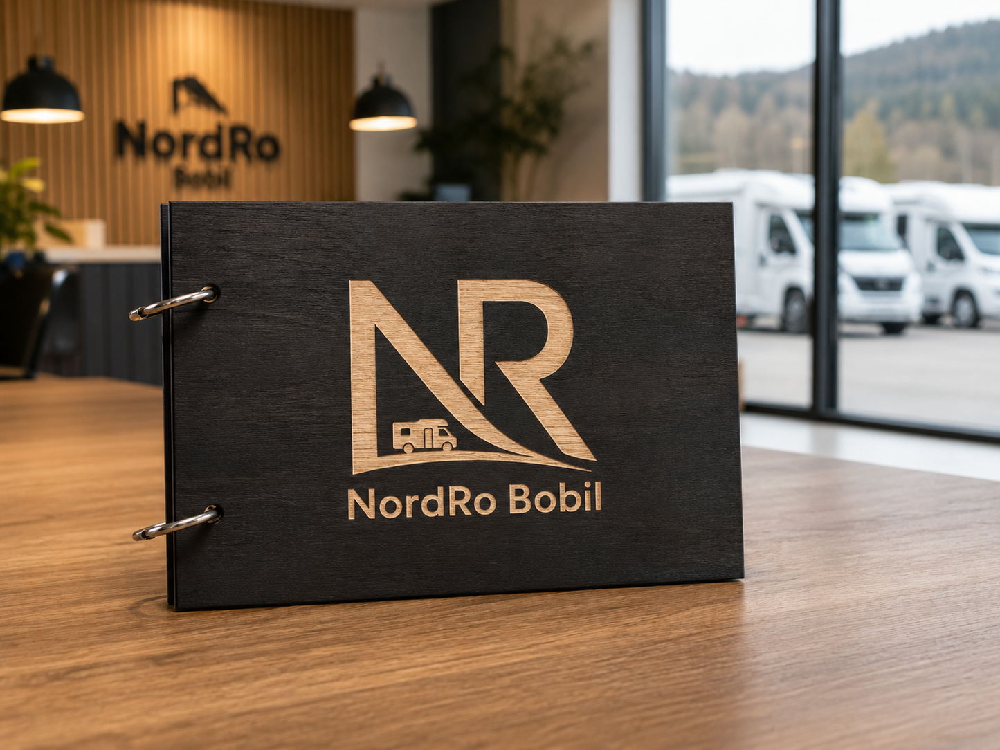 Firmalogo gravert på bobilbok i tre