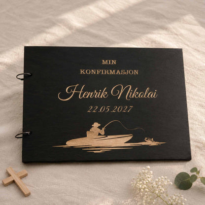 Svart personlig konfirmasjonsbok i tre med gravert fiskebåt