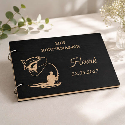 Svart personlig konfirmasjonsbok i tre med gravert fisker og fisk