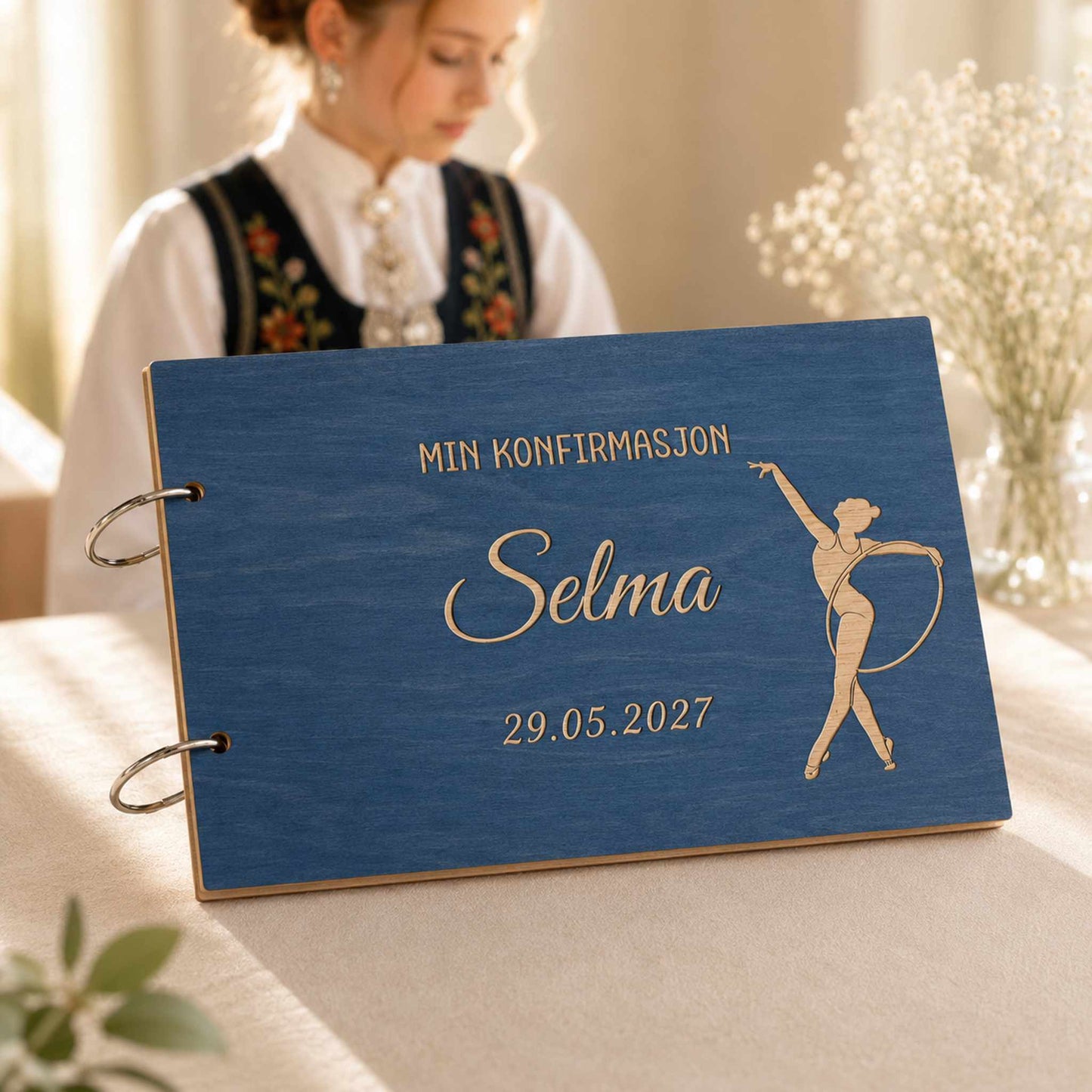 Blå personlig konfirmasjonsbok i tre med gravert gymnastikkmotiv