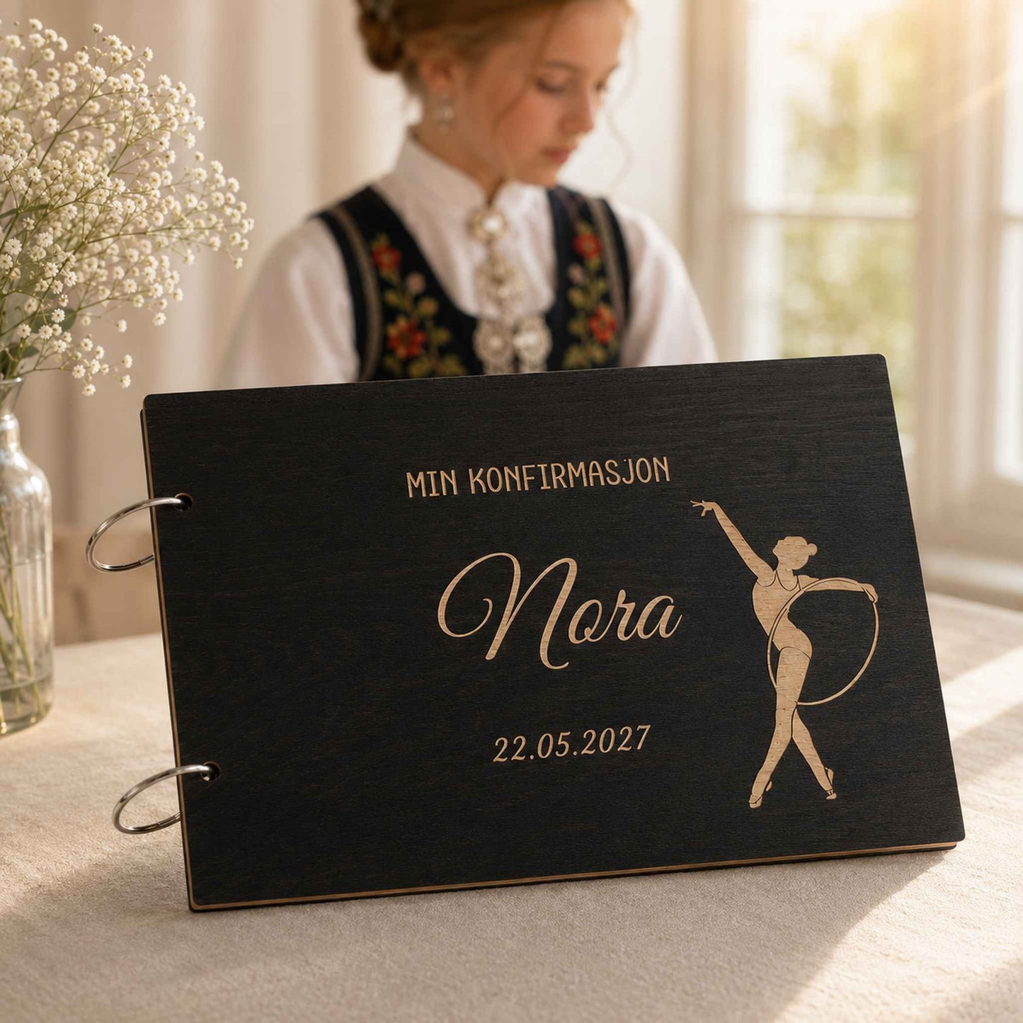 Svart personlig konfirmasjonsbok i tre med gravert gymnastikkmotiv