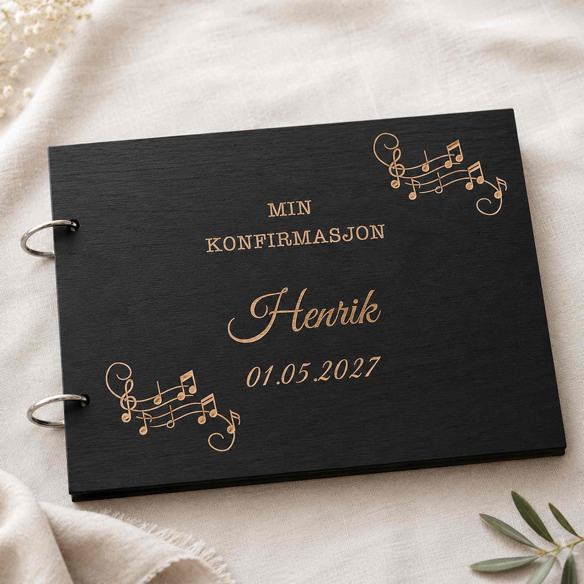 Svart personlig konfirmasjonsbok i tre med gravert musikkmotiv